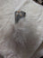 Gray fuzzy pom-pom keychain with small owl clip attached to a cotton canvas squirrel coin purse with sheepskin tail