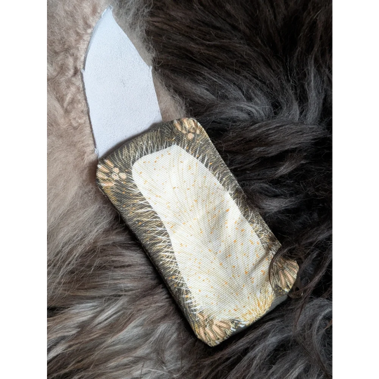 Squirrel coin purse made of olive green cotton canvas with cream floral edges and a soft sheepskin tail detail