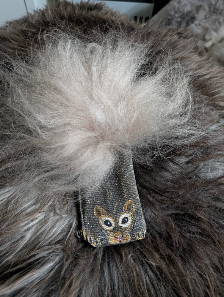 A charming dark gray coin purse with a cute squirrel face and fluffy white sheepskin tail pom-pom on cotton canvas
