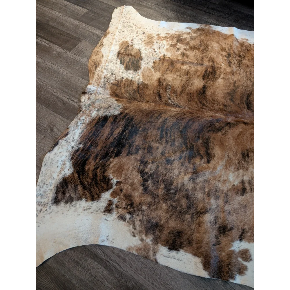 Large cowhide rug with brown and white natural irregular patterns showcasing unique characteristics and beautiful rugs quality