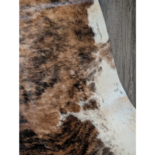 Beautiful large cowhide rug in brown and white with natural fur texture showcasing unique characteristics