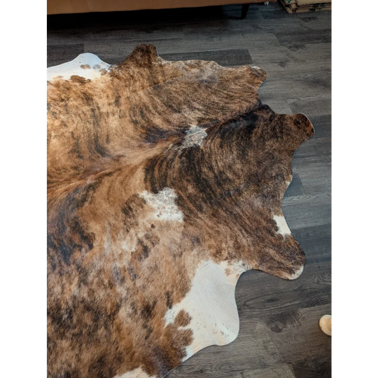 Large cowhide rug in brown and white with natural fur texture showcasing unique characteristics for beautiful rugs