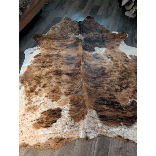 Large cowhide rug with natural brown and white fur texture featuring unique characteristics for beautiful rugs