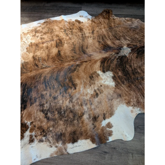 Large brown and white cowhide rug with beautiful natural irregular patterns showcasing unique characteristics