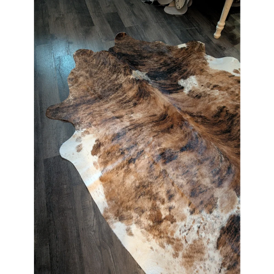 Large brown and white cowhide rug with beautiful natural irregular patterns and unique characteristics perfect for decor