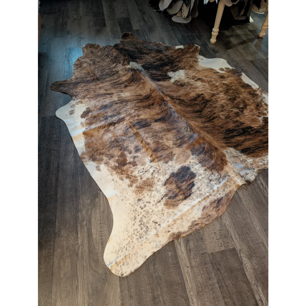 Large cowhide rug in brown and white with beautiful irregular patterns showcasing unique characteristics