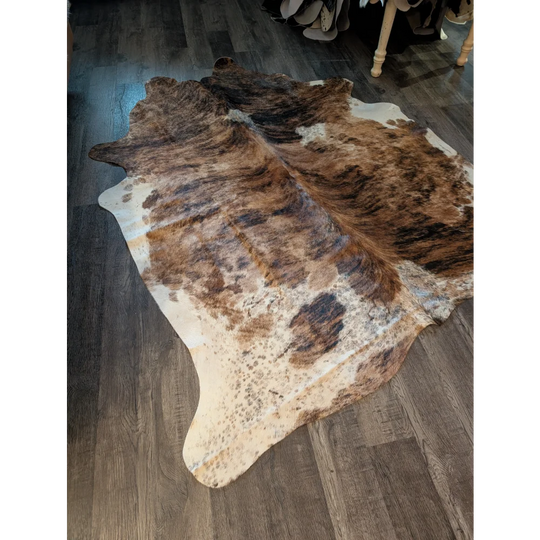 Large cowhide rug in brown and white with beautiful irregular patterns showcasing unique characteristics