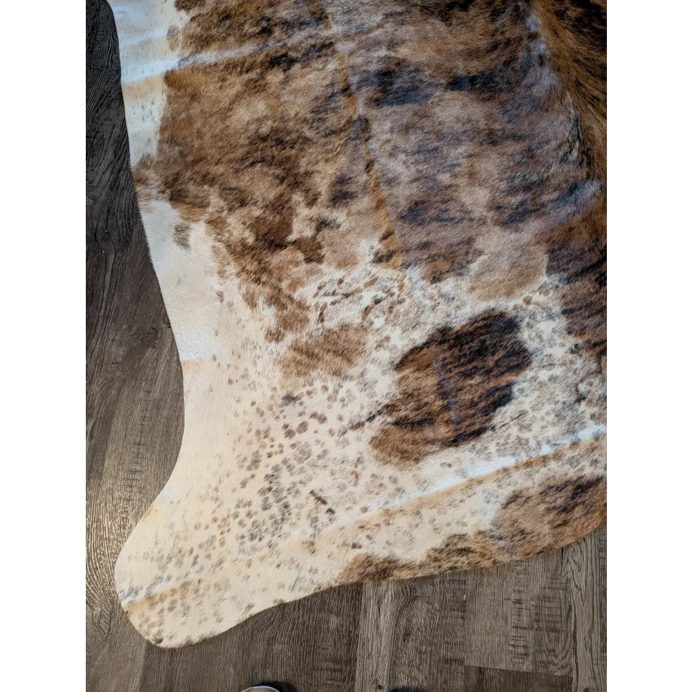 Large cowhide rug with beautiful brown and white natural fur texture showcasing unique characteristics