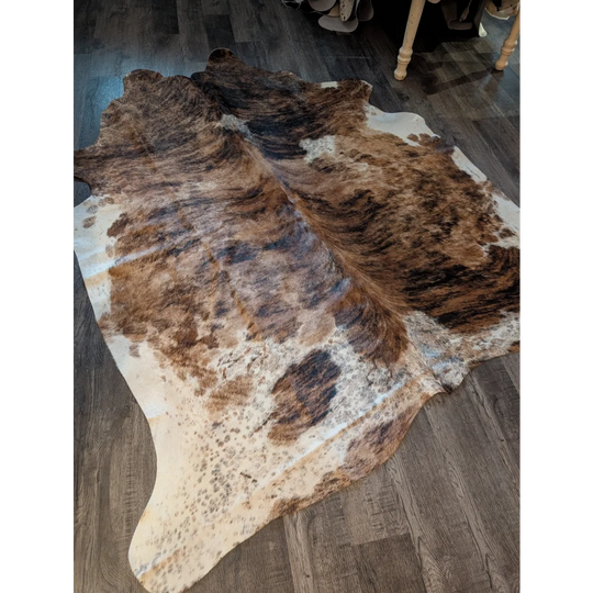 Large cowhide rug in brown and white with unique natural irregular patterns perfect for beautiful rugs collection