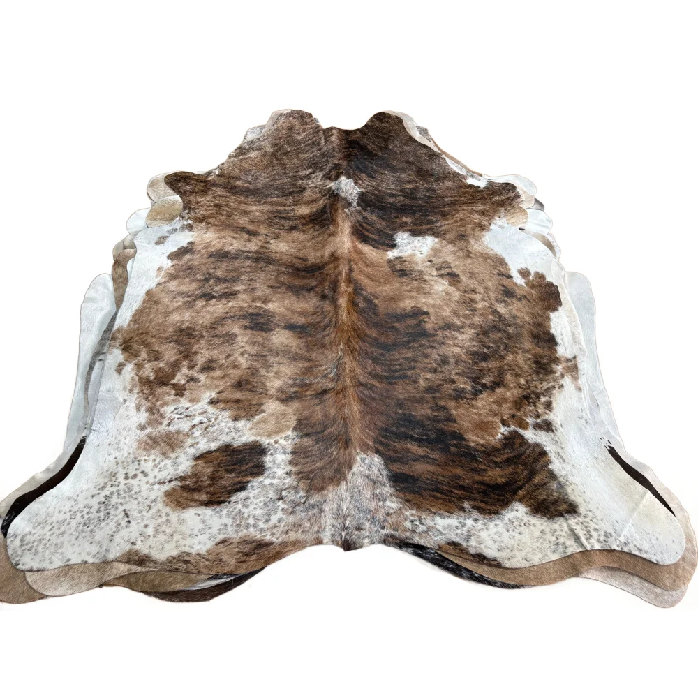 Brown and white large cowhide rug with beautiful natural irregular edges showcasing unique characteristics
