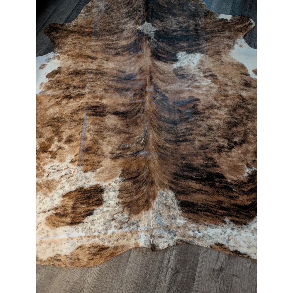 Large brown and white cowhide rug with natural fur texture featuring unique characteristics perfect as beautiful rugs