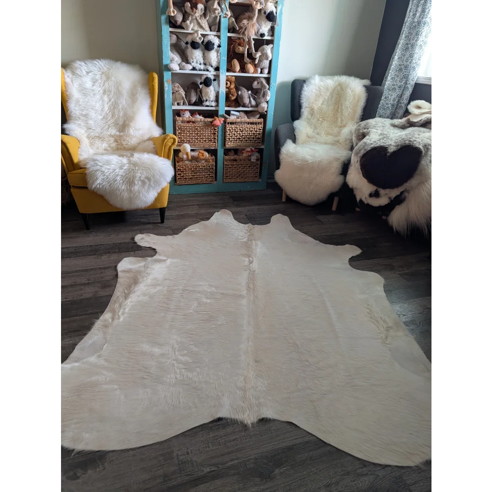Cream-colored large cowhide rug with soft fluffy texture and unique irregular shape perfect for beautiful rugs displays