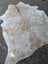 Large cowhide rug in natural white and tan with soft textured surface perfect for adding rustic charm to any space