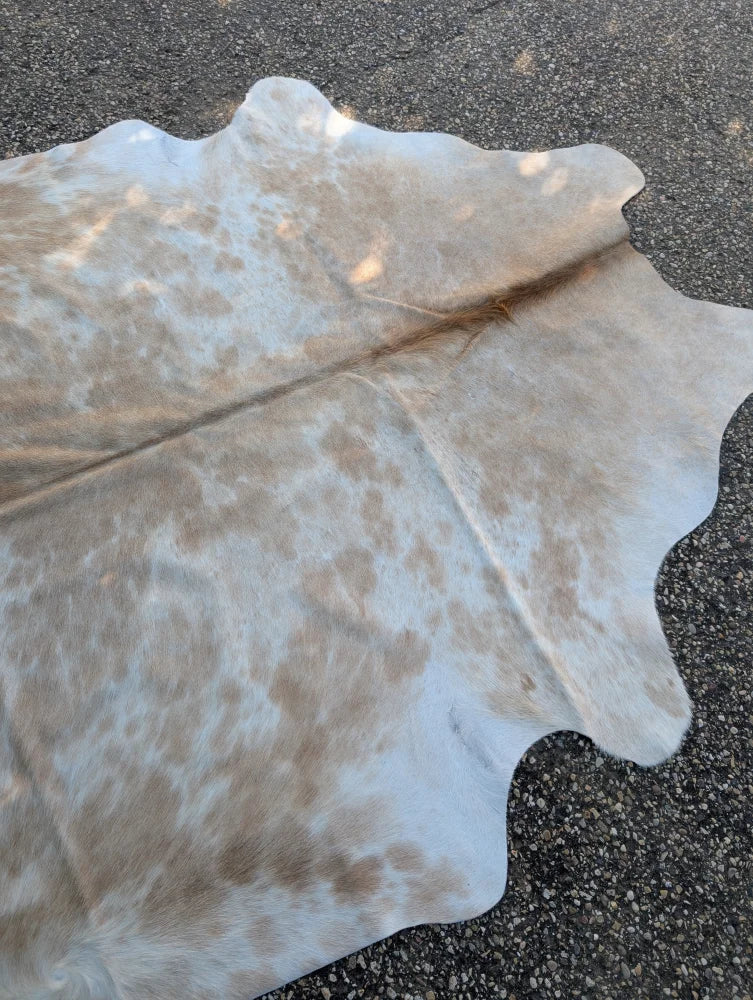 Large cowhide rug in natural white and tan with a soft textured surface adding rustic charm to any space