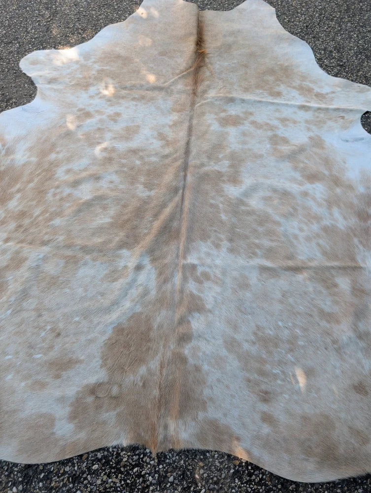 Large cowhide rug in natural tan and white with soft texture adding rustic charm to beautiful rugs