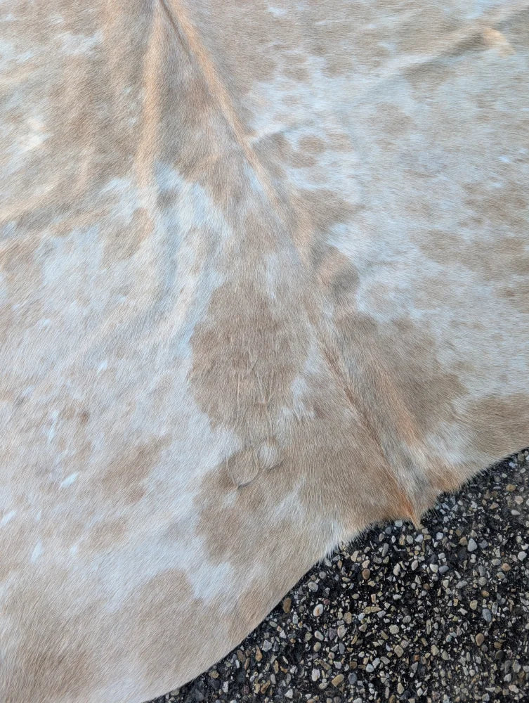Large cowhide rug in natural tan and white with soft texture adds rustic charm to any space as a beautiful rug
