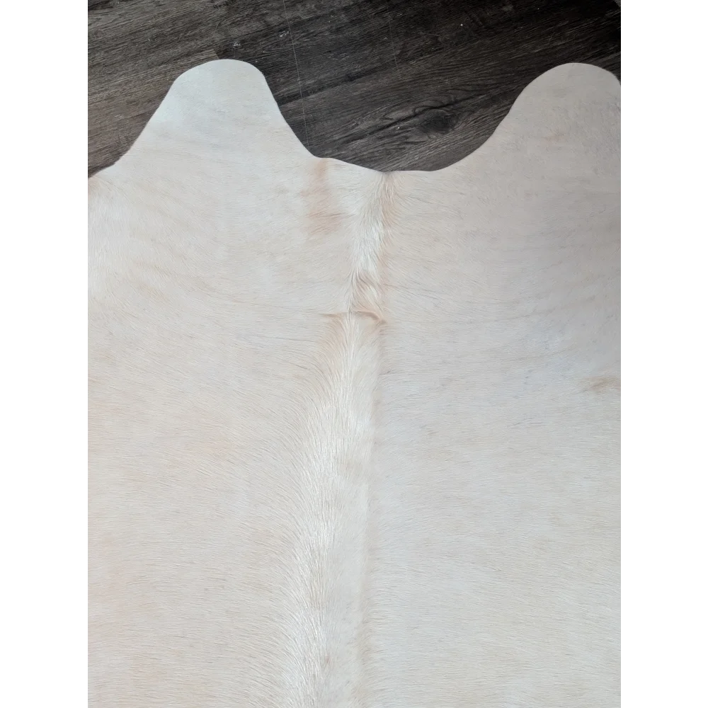 Large cowhide rug in pale beige with natural fur texture and subtle tan markings perfect for beautiful rugs collection