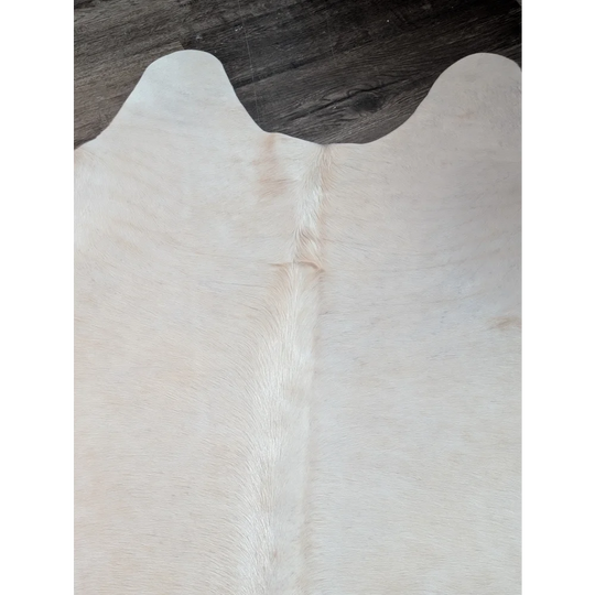 Large cowhide rug in pale beige with natural fur texture and subtle tan markings perfect for beautiful rugs collection