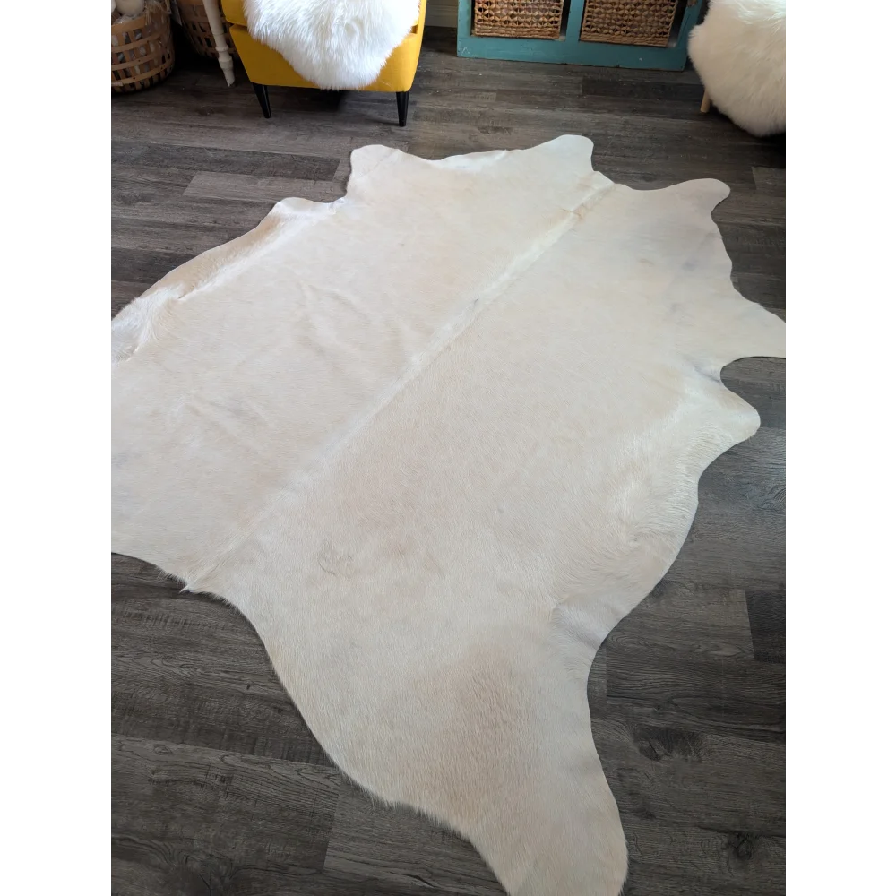 Large cowhide rug in pale beige with natural fur texture and unique irregular edges perfect for beautiful rugs collections