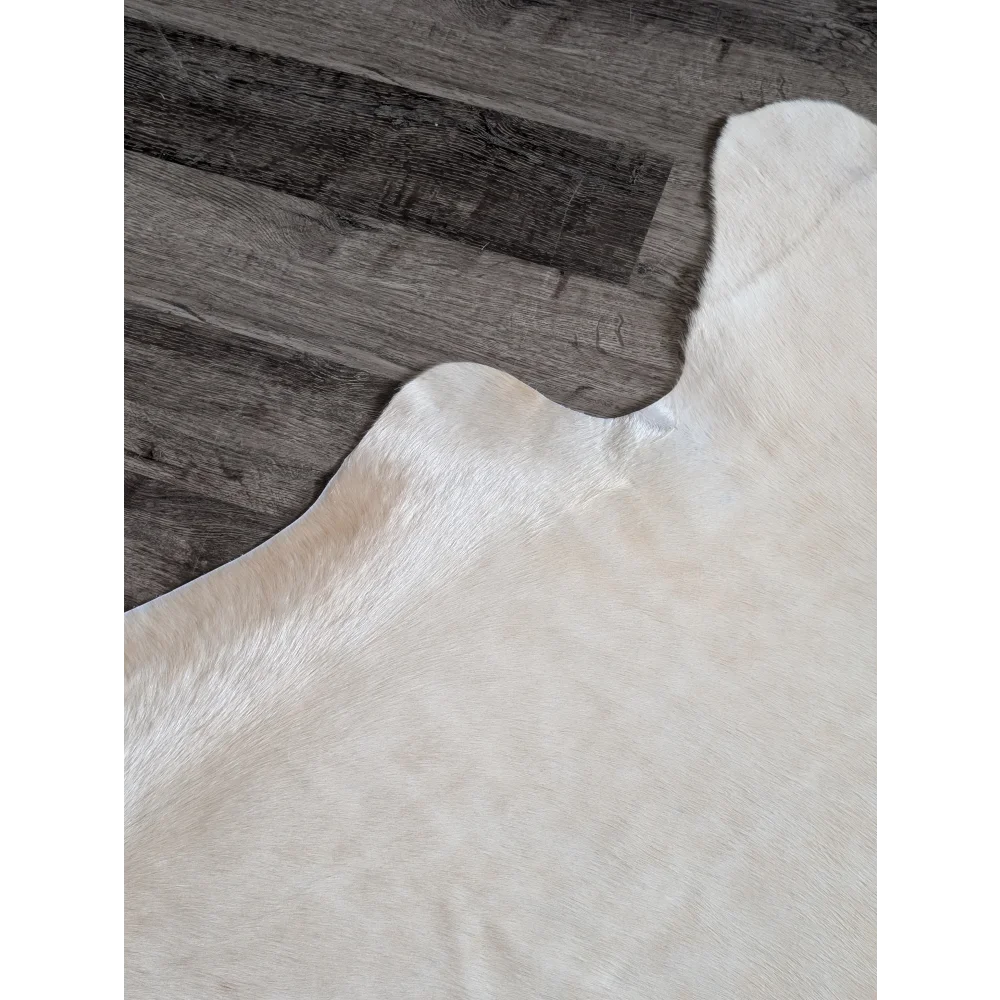 Cream-colored large cowhide rug with soft natural texture and unique irregular edges perfect for beautiful rugs collection