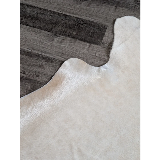 Cream-colored large cowhide rug with soft natural texture and unique irregular edges perfect for beautiful rugs collection