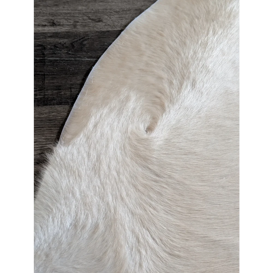 Large cream-colored cowhide rug with soft natural fur texture and unique characteristics perfect for beautiful rugs