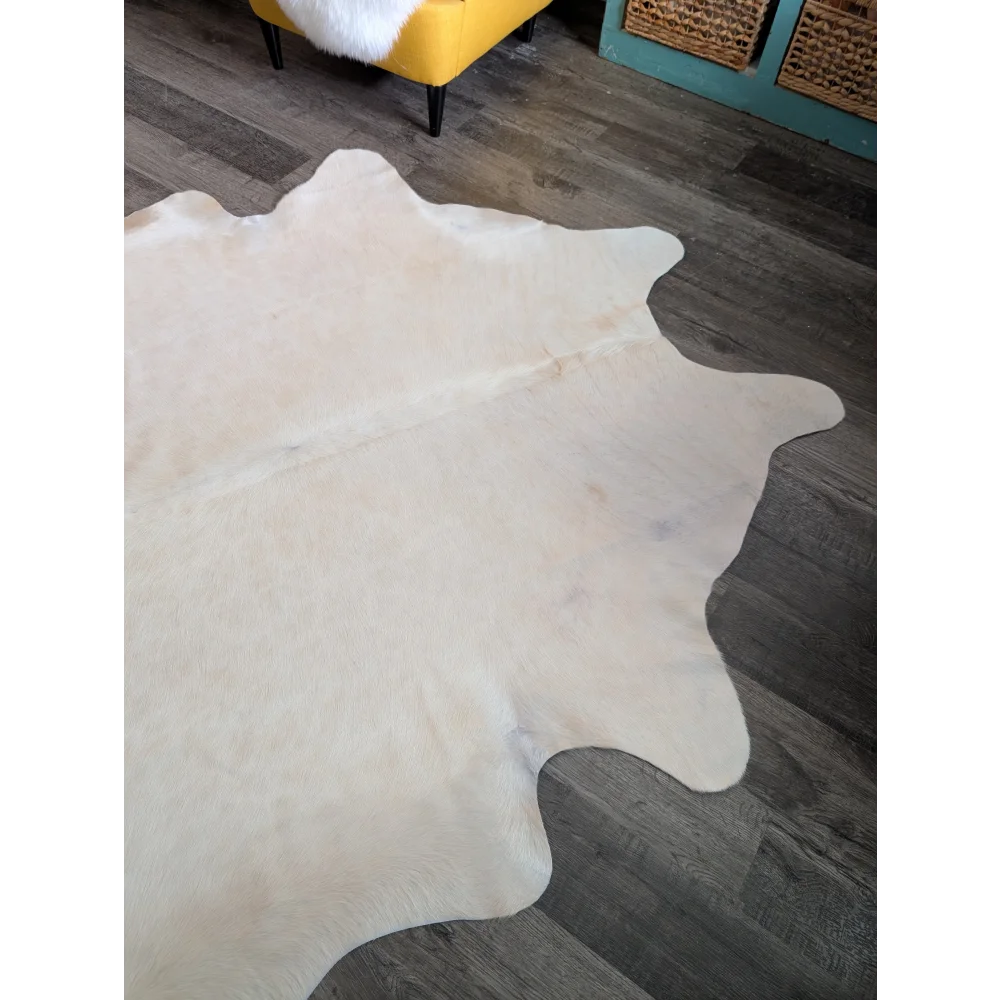 Large cowhide rug with pale beige natural white color and unique characteristics perfect for beautiful rugs collection