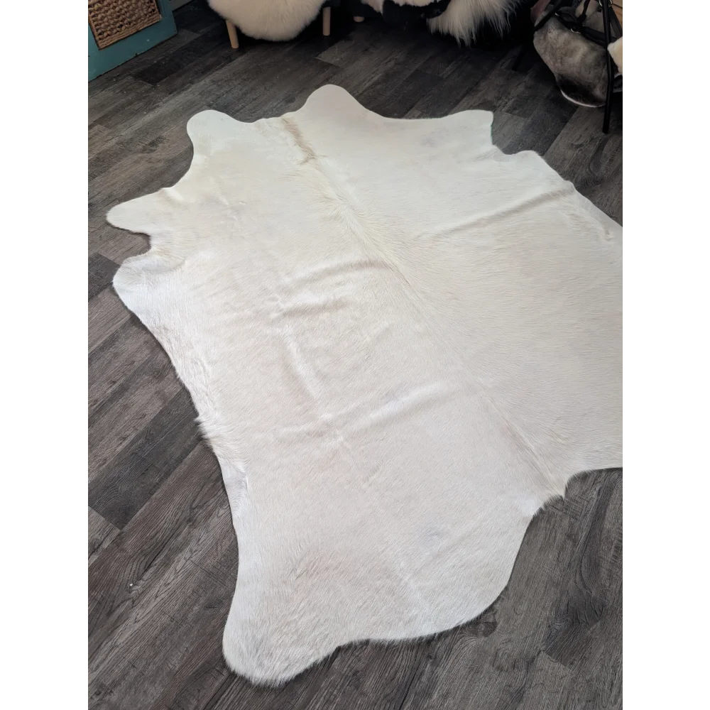 Large cowhide white ivory rug with natural shape and soft fluffy texture featuring unique characteristics
