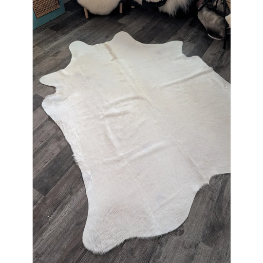 Large cowhide white ivory rug with natural shape and soft fluffy texture featuring unique characteristics