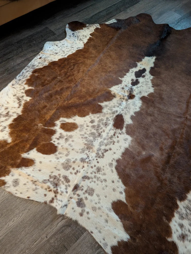 Large brown and white cowhide rug with natural fur texture showcasing unique characteristics for beautiful rugs