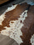 Large brown and white cowhide rug with natural fur texture showcasing unique characteristics for beautiful rugs