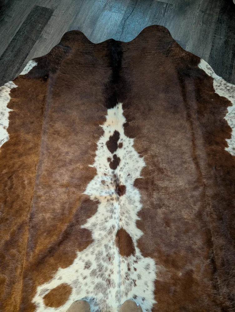 Beautiful large cowhide rug in brown and white with natural fur texture showcasing unique characteristics