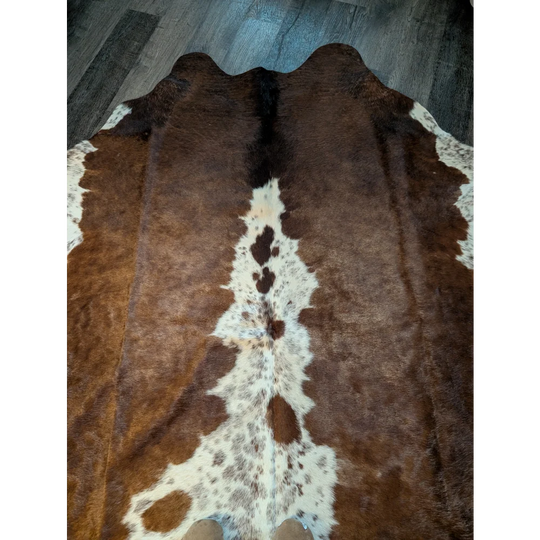 Beautiful large cowhide rug in brown and white with natural fur texture showcasing unique characteristics