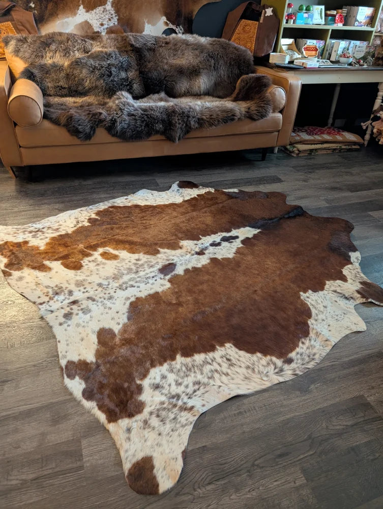 Large cowhide rug featuring beautiful brown and white patterns with unique natural characteristics perfect for decor