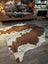 Large cowhide rug featuring beautiful brown and white patterns with unique natural characteristics perfect for decor