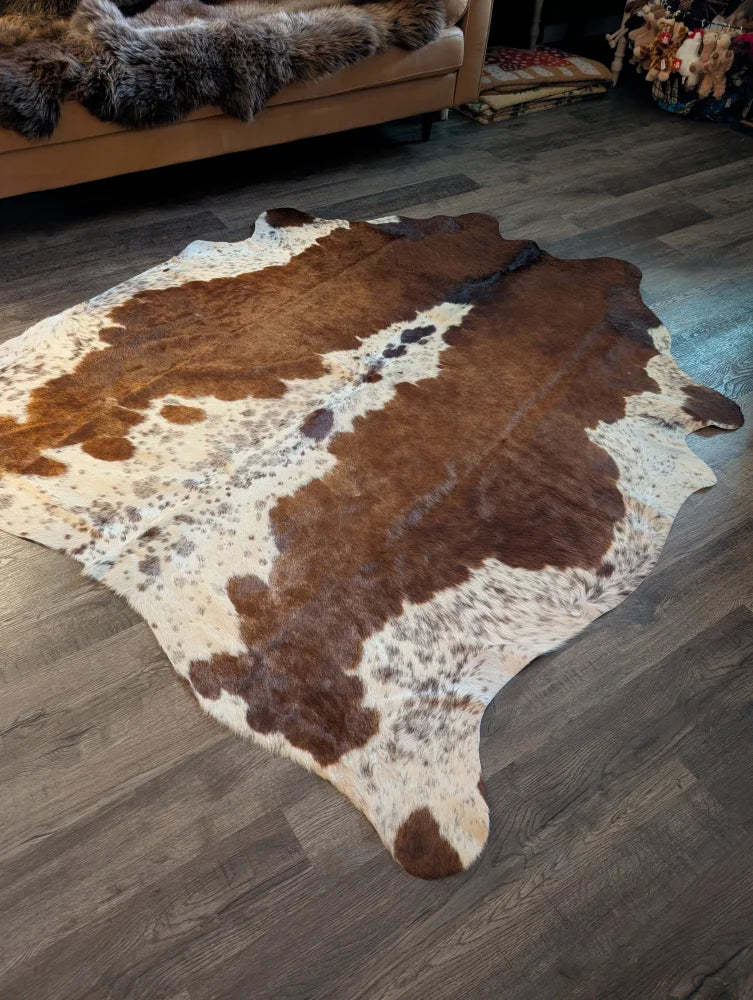 Brown and white large cowhide rug with natural fur texture showcasing unique characteristics in beautiful rugs style