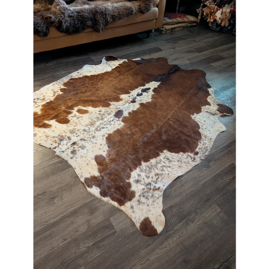 Brown and white large cowhide rug with natural fur texture showcasing unique characteristics in beautiful rugs style