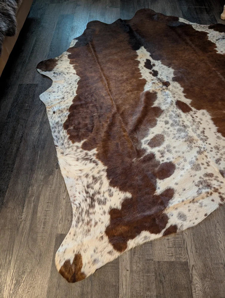 Gorgeous large brown and white cowhide rug with natural fur texture and unique characteristics for beautiful rugs