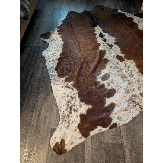 Gorgeous large brown and white cowhide rug with natural fur texture and unique characteristics for beautiful rugs