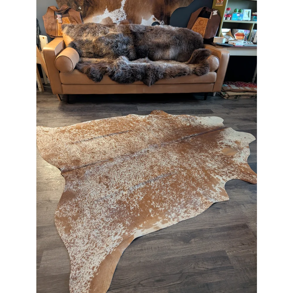Large cowhide rug in brown and white speckles with unique characteristics perfect for beautiful rugs enthusiasts