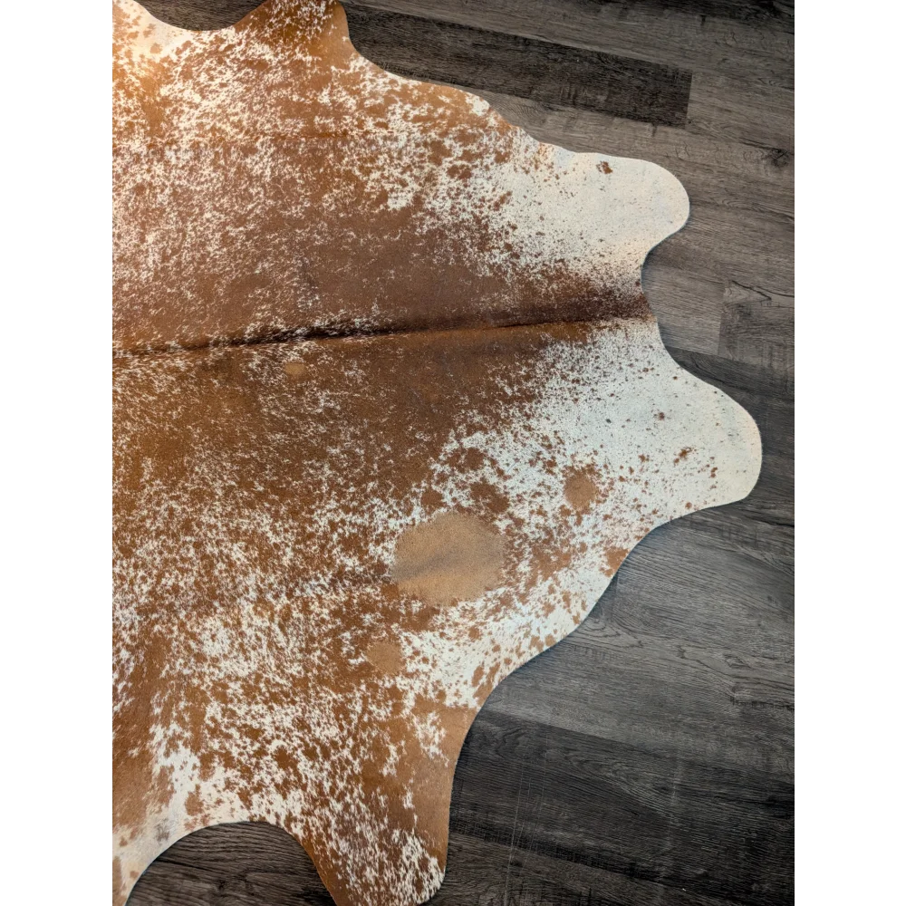 Beautiful large cowhide rug in brown and white with unique characteristics and a natural irregular edge