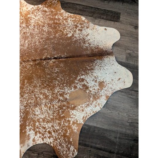 Beautiful large cowhide rug in brown and white with unique characteristics and a natural irregular edge