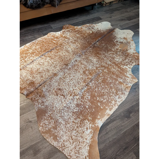 Large cowhide brown and white speckled rug with beautiful irregular edges showing unique characteristics