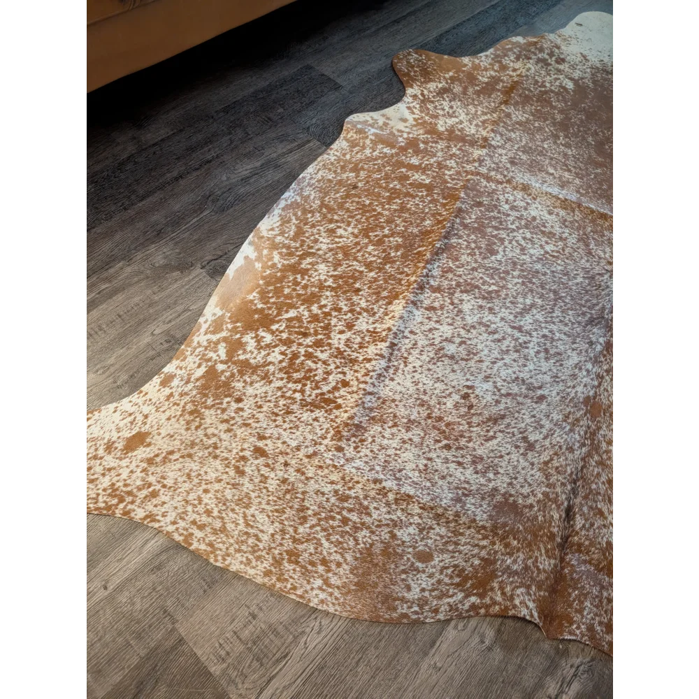 Large beautiful rug featuring brown and white speckled cowhide with unique characteristics measuring 82 by 74 inches