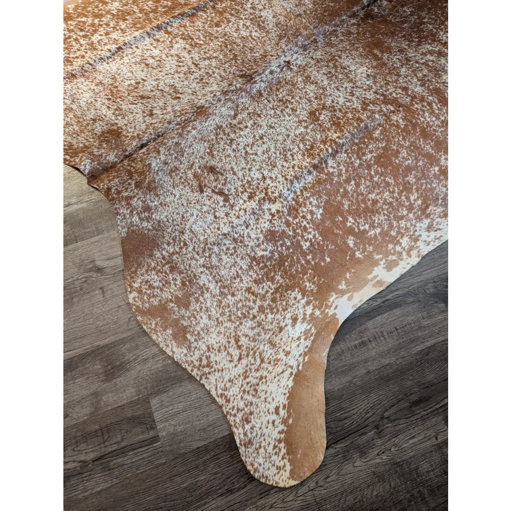 Brown and white speckled large cowhide rug with natural edges showcasing beautiful rugs unique characteristics