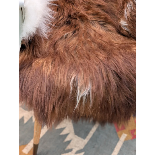A plush long wool icelandic sheepskin throw blanket in brown and white faux fur soft fluffy texture 50 x 39 inches