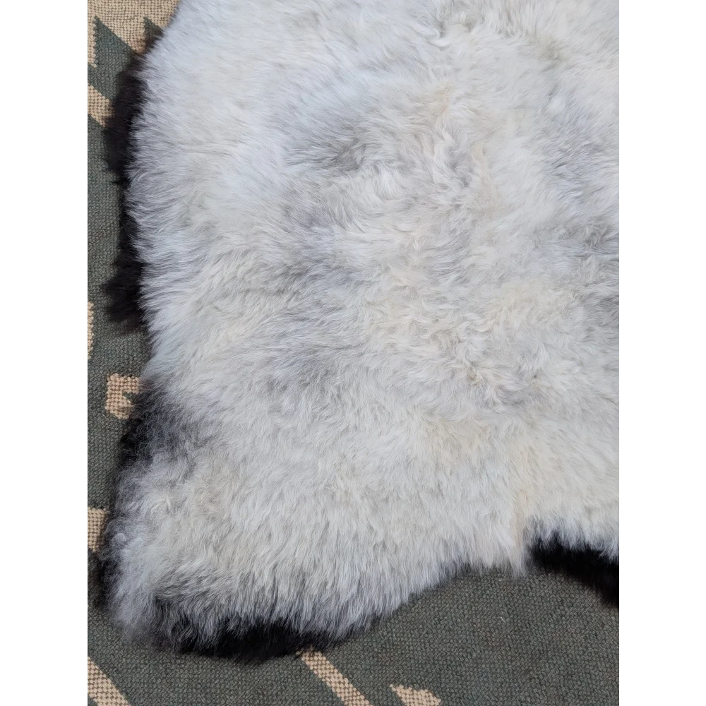 A soft fluffy white icelandic sheepskin rug with long wool and natural mottled texture from angus oliver