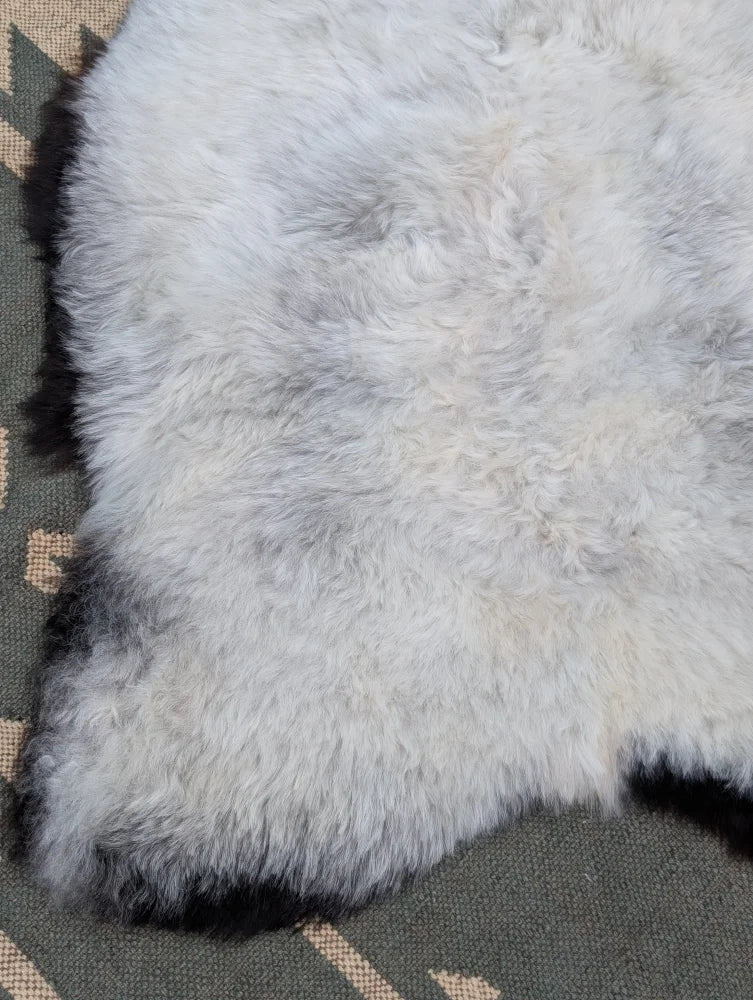 A soft fluffy white icelandic sheepskin rug with long wool and natural mottled texture from angus oliver