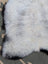 A soft fluffy white icelandic sheepskin rug with long wool and natural mottled texture from angus oliver