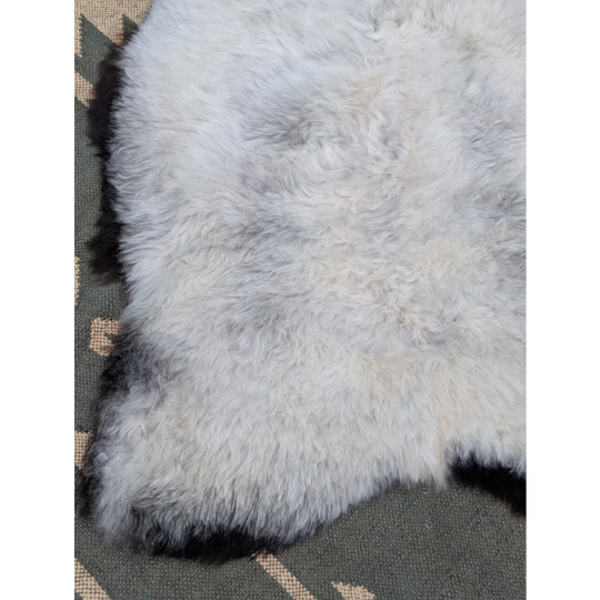 A soft fluffy white icelandic sheepskin rug with long wool and natural mottled texture from angus oliver